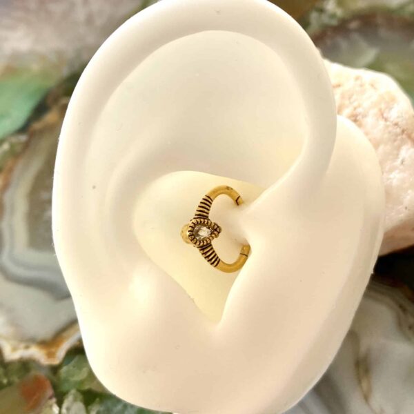 Anneau / clicker ovale plaqué or avec un motif ethnique et un diams central